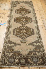 Vintage Oushak runner with mirrored mehrab, meandering leaf border in bronze and apricot.