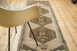 Ornate bronze and apricot medallion design on a vintage Oushak rug runner.