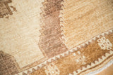 Detailed corner of vintage Oushak carpet featuring simplistic tribal geometric patterns in brown and ivory.