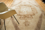 Vintage hand-knotted Oushak rug corner, tribal diamond outline with floral motifs in ivory and bronze.
