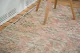 Distressed faded blush Oushak runner with repeating floral bouquets and quatrefoil pattern.