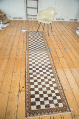 Repeating ivory and brown checkerboard pattern with wave motif on vintage Oushak runner.