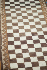 Natural ivory and brown checkered pattern and wave motif border of a vintage Oushak.