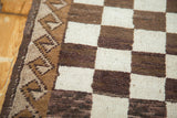 Vintage Oushak runner edge with natural ivory and brown checkered pattern, wave motif border.