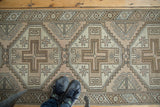 Lower end of Vintage Oushak rug runner, showing tribal geometric borders and faded neutral tones.