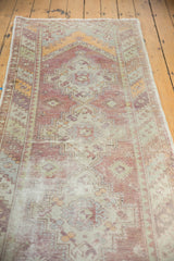 Vintage Oushak runner displaying distressed texture and muted purple, orange, and green tones.
