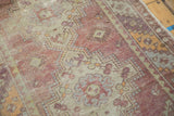 Distressed Oushak runner detail: faded eggplant, sea foam green patterns, visible wear.
