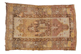 Tattered vintage Oushak rug with an ornate medallion in yellow, mauve, beige, 3'8