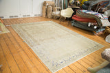 Angled view of a distressed Sivas carpet showing its soft ivory field and cobalt blue details.