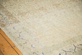 Cobalt blue border motifs and the distressed, low-pile texture of a vintage ivory Sivas carpet.