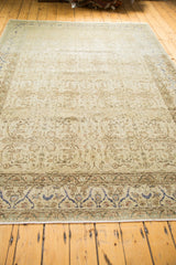 Angled view of a distressed Sivas carpet's ivory field and cobalt blue border.