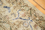 Distressed, low-pile texture of a vintage ivory Sivas carpet with pops of cobalt blue.
