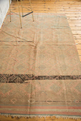Bold black geometric band with pink and gray patterns on a vintage Jijim rug.