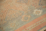 Vintage Jijim rug features raised geometric embroidery in soft pink and muted blue-gray.