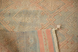 Pink geometric embroidery on a vintage Turkish Jijim rug, with striped hand-loomed backing.