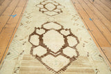 Hand-knotted Oushak runner detail, bold chocolate brown medallion on faded ivory.