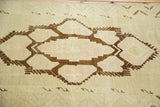 Vintage Oushak rug detail: bold chocolate brown geometric medallion outlines with abrash.