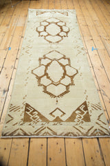 Oushak runner end, chocolate brown geometric patterns, faded blush and ivory background, short fringe.