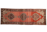 Vintage Oushak runner: serrated medallions on abrashed cinnabar red field, chocolate floral border.