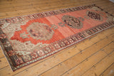 Secure fringe on vintage Oushak runner, showing dark chocolate floral and meandering minor border.