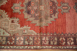 Vintage Oushak rug: abrashed cinnabar field meets dark chocolate border with splayed floral bouquets.