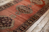 Secured end of the vintage Oushak runner, showcasing dark chocolate floral border.