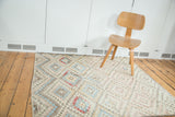 Vintage Oushak rug's distressed geometric diamond pattern in muted pastel colors.