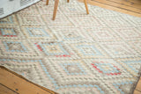 Distressed texture on a vintage Oushak geometric diamond pattern in soft colors.