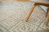 Distressed Oushak rug with geometric pink, cream, and muted blue squares.