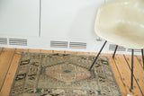 Visible section of the Oushak rug showing blush quatrefoil, teal diamond, and hook motifs.