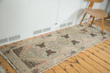 Distressed vintage Oushak runner with faded blush, silver, and brown geometric patterns.