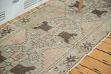 Textured pile of the distressed Oushak runner with faded blush, silver, and brown patterns.