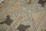 Distressed Oushak runner pile featuring faded blush and silver tones with rich chocolate brown motifs.