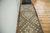 Funky checkered pattern of the distressed vintage Oushak runner with ivory, brown, and green.
