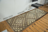 Textured checkered vintage Oushak runner in ivory and brown with secured edges.
