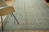 Distressed corner of the vintage Kaisary rug showing copper green geometric pattern and fringe.