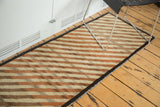Vintage Gabbeh runner's diagonal ivory and copper stripes with speckled abrashes and dark selvedge.