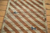 Ivory and copper diagonal stripes on plush Gabbeh runner with blue animal motif.