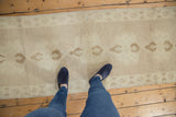 Subtle mauve field with faded medallions and geometric border on a vintage Oushak runner.
