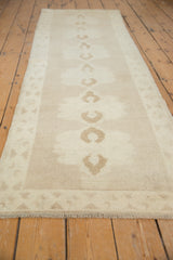 Hand-knotted fringe and geometric triangular border in ivory and soft bark brown.
