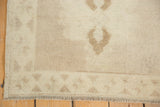 Vintage Oushak rug fringe and geometric triangular border in subtle mauve and ivory.
