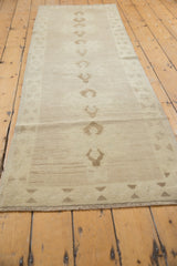 Detail of the Oushak rug's secured fringe and soft brown geometric triangular border.