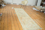 Vintage Oushak runner with faded medallions on a sand ivory field and subtle greens.