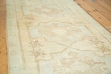 Soft faded sand and light brown starburst patterns on a vintage Oushak runner.