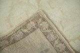 Secured edge of vintage Turkish Oushak runner with faded bronze and blush border pattern.