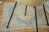 Distressed vintage Oushak rug texture in soft sand and dusty blue.