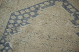 Decorative distressed pile on vintage Oushak rug, soft sand and dusty blue pattern.