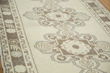 Distressed vintage Turkish Oushak runner's scalloped medallions and arabesques in beige, silver, brown.