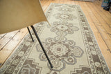 Distressed vintage Oushak runner with beige scalloped medallions and brown serpent arabesques.
