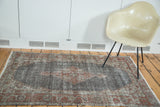 Distressed vintage Oushak rug with faded brick red medallion, dark brown field, and historic patina.